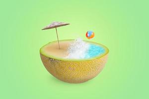 Beach with sea waves, parasol and ball on half a melon. The concept of summer refreshment with fruit and vitamins. Green background photo