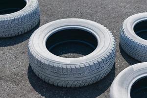 A used white car tire is lying discarded on the road photo