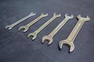 Set of new wrenches made of chromium and vanadium alloy on a dark surface photo