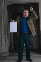 Office worker with problems holding a sheet of paper in the catacombs photo