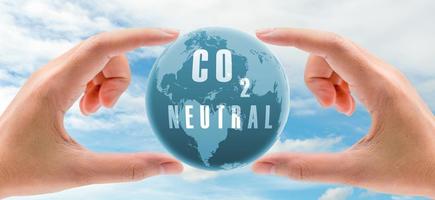 Carbon neutral concept. Hand holding CO2 neutral in globe map on blue sky and white clouds background. Environment day. Carbon neutral web banner. Environment issue. Global carbon neutrality concept. photo