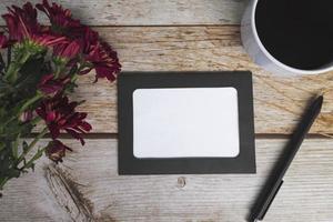 Chalkboard frame on wooden desk. Directly above, flat lay, copy space. photo