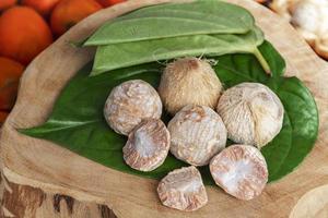 Betel nut or areca nut with betel leaf isolated on wooden background. photo