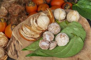 Betel nut or areca nut with betel leaf isolated on wooden background. photo