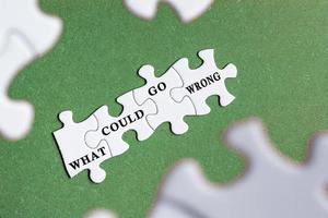 What could go wrong text on white jigsaw puzzle with some missing pieces. photo