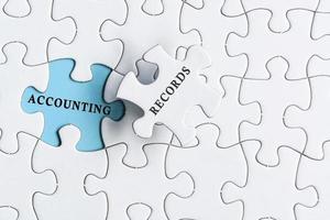 Accounting records text on blue background of white jigsaw puzzle. photo