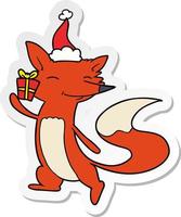sticker cartoon of a happy fox wearing santa hat vector