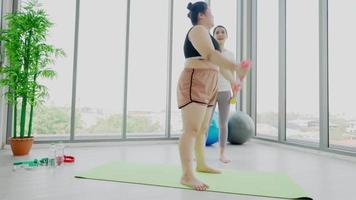 entrenador de fitness ayudando a la mujer a hacer ejercicio video
