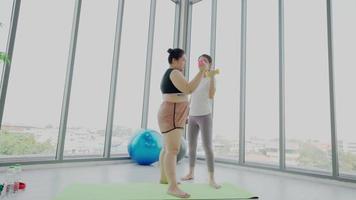 fitnesstrainer die vrouw helpt om te oefenen video
