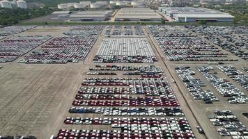 Aerial.new car storage parking lot showing imported new vehicles or ready to export new automobiles storage facility car industry for export all over the world market for car sales video