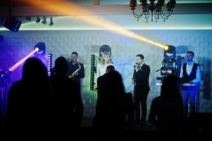 Live music performance with enthusiastic crowd and stage lighting