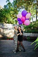 Two girls wear on black with balloons at hen party. photo