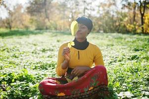 African american girl at yellow and red dress at autumn fall park. photo