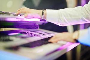 Hand of keyboardist on stage with lights. photo