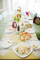 Delicious meals such as salad and canapes laying on the laid table. photo