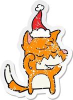 friendly distressed sticker cartoon of a fox waking up wearing santa hat vector