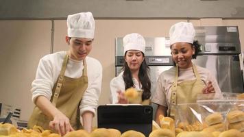 tres jóvenes socios de inicio de chefs, blogger de pequeñas empresas que transmiten en vivo a través de tecnología de aplicaciones móviles, promoción de ventas de panadería en línea, pan fresco, comida de pastelería y cocina comercial. video