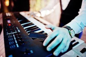 Hand of keyboardist on stage with lights. photo