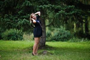 Portrait of gorgeous girl wear on black at hen party, posed at park. photo