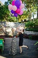 Two girls wear on black with balloons at hen party. photo
