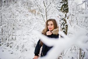 Beautiful brunette girl in winter warm clothing. Model on winter jacket. photo