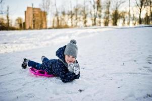 Cute little girl with saucer sleds outdoors on winter day. photo