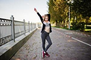 Young girl has the training and doing exercise outdoors. Sport, fitness, street workout concept. photo