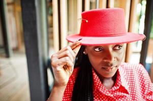 Close up portrait of pretty braids business african american lady bright bossy person friendly wear office red shirt and hat. photo