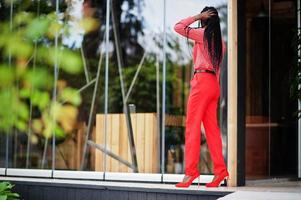 Pretty braids business african american lady bright bossy person friendly wear office red shirt and trousers. photo