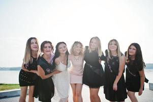 Group of 7 girls wear on black and 2 brides at hen party. photo