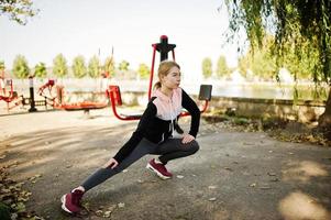 la joven tiene el entrenamiento y hace ejercicio al aire libre en simuladores callejeros. deporte, fitness, concepto de entrenamiento callejero. foto