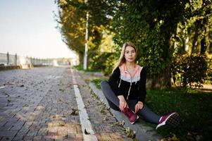 Young girl has the training and doing exercise outdoors. Sport, fitness, street workout concept. photo