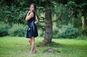 Portrait of gorgeous girl wear on black at hen party, posed at park. photo