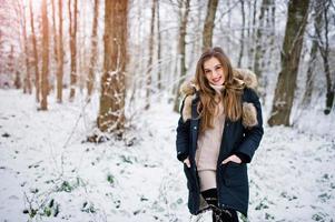 Beautiful brunette girl in winter warm clothing. Model on winter jacket. photo