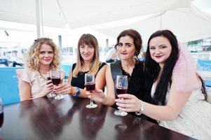 grupo de 4 chicas en negro con copas de champán en despedida de soltera. foto