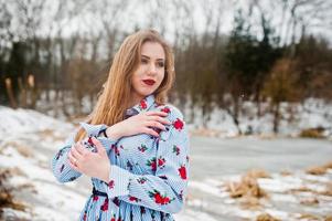 Stylish girl in dress at winter day against frozen lake. photo