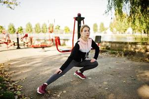 la joven tiene el entrenamiento y hace ejercicio al aire libre en simuladores callejeros. deporte, fitness, concepto de entrenamiento callejero. foto