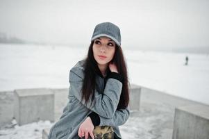Stylish brunette girl in gray cap, casual street style on winter day. photo