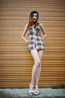 Amazing long legs with hig heels girl wear on hat against shutter. photo