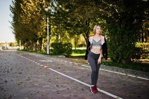 la joven tiene el entrenamiento y hace ejercicio al aire libre. deporte, fitness, concepto de entrenamiento callejero. foto