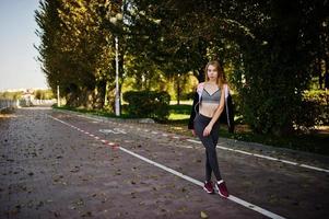 la joven tiene el entrenamiento y hace ejercicio al aire libre. deporte, fitness, concepto de entrenamiento callejero. foto