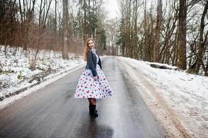 chica elegante con chaqueta de cuero en el día de invierno en la carretera. foto