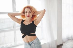 Joy and happiness. Attractive redhead woman posing in the spacey room near the window photo