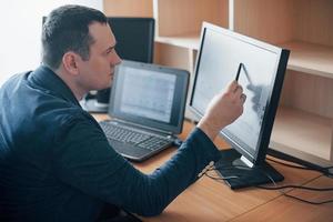 Veo cómo el hombre se había preocupado en este momento. examinador de polígrafo trabaja en la oficina con el equipo de su detector de mentiras foto