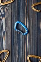 Vertical photo. Isolated photo of climbing equipment. Parts of carabiners lying on the wooden table