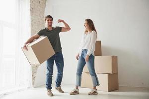 mostrando músculos. la familia tiene mudanza a una nueva casa. desempacar cajas de mudanza foto