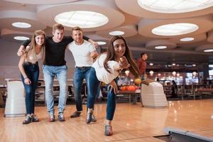 Attractive people. Young cheerful friends have fun in bowling club at their weekends photo