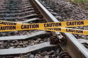Terrorism conception. Dangerous explosive lying on the railway. Yellow caution tape in front