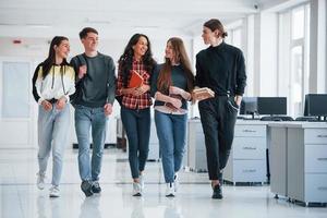 Work will not wait. Group of young people walking in the office at their break time photo