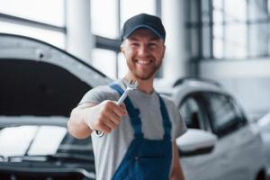 Call us if you need help. Employee in the blue colored uniform stands in the automobile salon photo